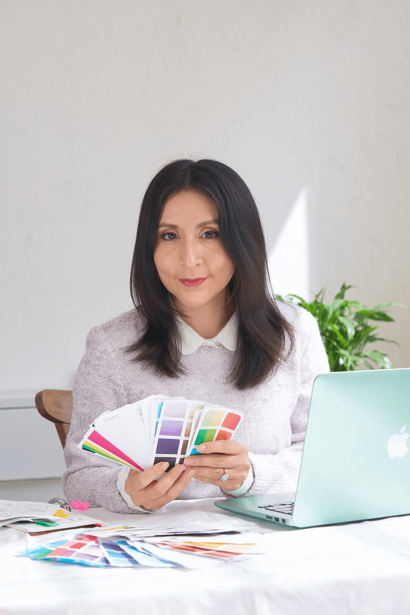 Vane mostrando cartas de color junto a una laptop